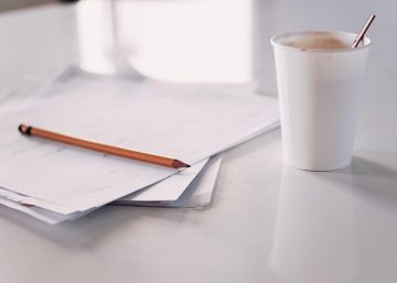 Papers on a desk with coffee